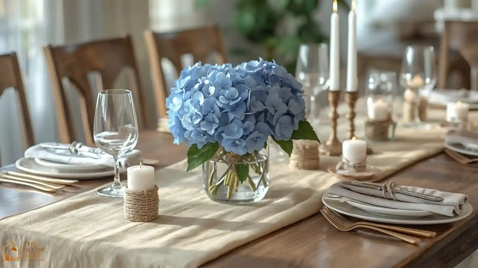 A holiday dining table set with a sand-colored linen runner, blue hydrangea centerpiece, and oyster shell place cards